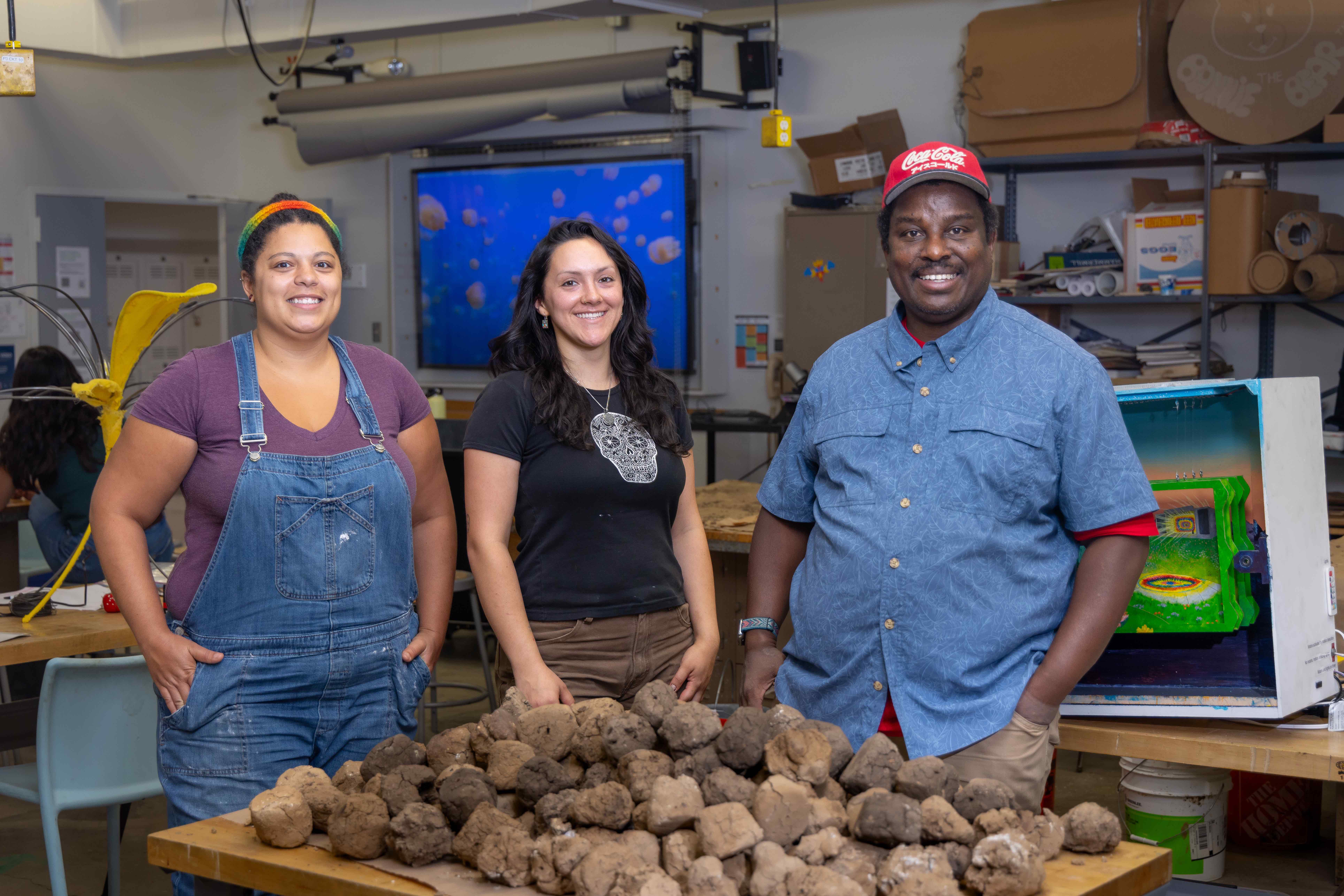 Christian, Josephine, and Walter in the sculpture lab posing with materials