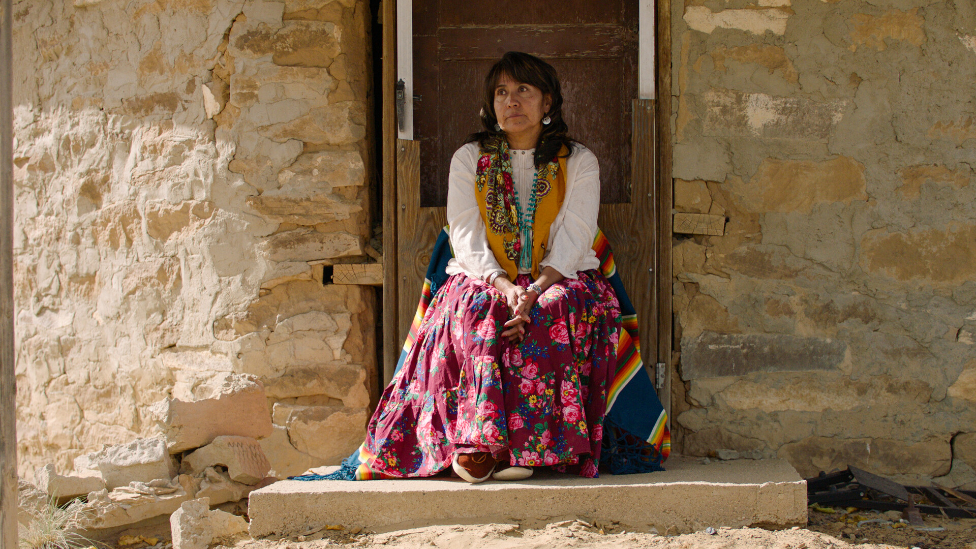 Navajo woman sitting in a doorway